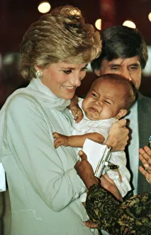Emotions Prints: Diana, Princess of Wales holding a baby during prize giving ceremonies on a visit to