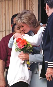 Diana, Princess of Wales, hugs a young girl who gave her flowers as she leaves Cook
