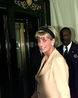 Diana, Princess of Wales, wearing sand coloured suit with black top and matching headband