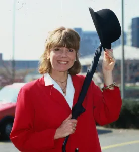 Diana Rigg actress April 1984 wearing red jacket holding bowler hat and umbrella