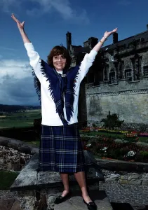 Diana Rigg actress Stirling Castle Scottish Rugby Union tartan skirt shawl arms raised
