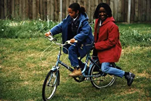 00145 Prints: Diane Louise Jordan on bike with young girl her niece Justine in blue jacket