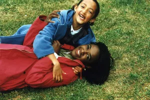 Diane Louise Jordan on grass with her niece Justine young girl in blue jacket