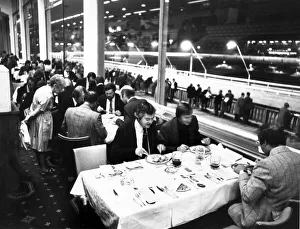 Eating Out Prints: Diners enjoying their meal at Belle Vue Greyhound stadium while punters line trails