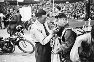 00448 Prints: Dirt Track races in London. (Picture shows) A competitor receiving treatment for an