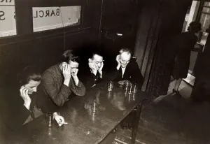 Rationing Prints: Disappointed drinkers sit around a table in a London pub with empty glasses as a result