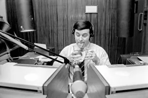 Headphones Prints: Disc Jockey Terry Wogan enjoys a large jug of water during broadcast of his afternoon