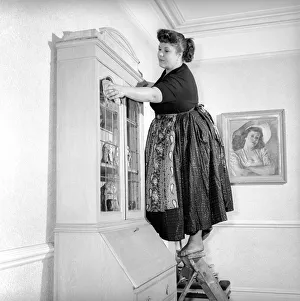 00067 Prints: Domestic Life: Woman (Mrs. Olive Haugh) dusting the bookcase: Circa 1954