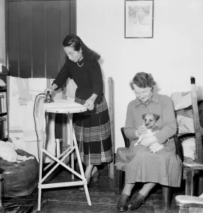 00008 Prints: Domestic Scenes A woman ironing in the living room of her home February 1953