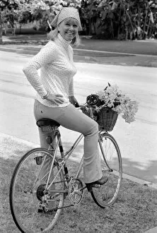 00325 Collection: Doris Day seen holding a bunch of flowers on her bicyle