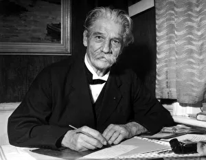 Dr. Albert Schweitzer sitting at desk writing letter October 1955