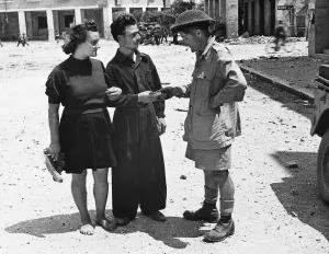 Driver M. A. Witcomb hands a cigarette to an Italian who has just returned to Littoria
