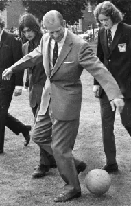 01430 Prints: Duke of Edinburgh, Prince Philip plays football during a visit to Bellingham Sports