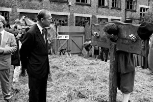 Images Dated 17th July 1987: The Duke of Edinburgh visits a film set, chatting to an actor in a pillory - 17 / 7 / 1987