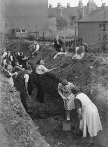 Shelter Prints: Eastenders seen here digging a trench for a communal air raid shelter in their back