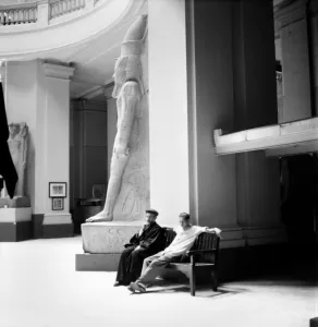 Egypt: Religion: A Coptic priest and his companion rest beside a statue of Ramese in