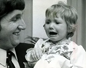 00102 Prints: Eighteen month old Clare Timewall held by her father Chris crying her eyes out after