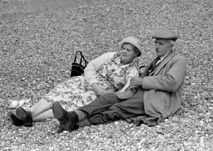 Elderly couple sunbathing on the pebble beach at Brighton July 1958