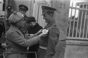 France Prints: Elderly french women pin flowers to the battle dress of Royal Marin soldiers in an