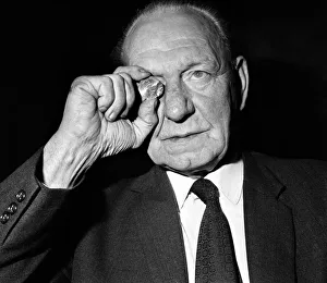 Elderly man studying a new fifty pence close up. November 1969 Z11025