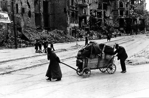 Struggle Prints: Elderly woman assisted by her husband walk through the Liepzig Strasse Berlin amid