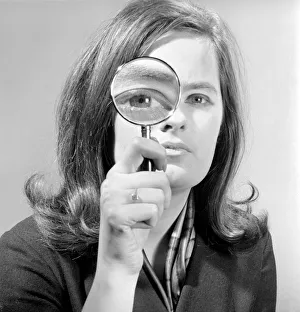 Elementary my dear Watson. Woman holding magnifying glass. Model: Jennie Cropper