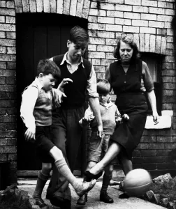 Brothers Prints: Elizabeth Charlton playing a game of football with her three sons Gordon aged 10