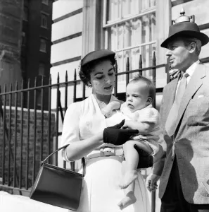 Elizabeth Taylor with the baby and Michael Wilding on the steps of the apartment
