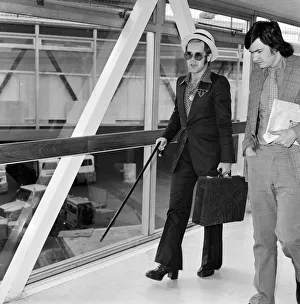 Walking Stick Prints: Elton John arrives at Heathrow airport from Arizona where he has been on holiday