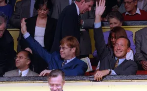 Knighthood Prints: Elton John centre singer and Watford FC Chairman waves to the crowd after receiving a