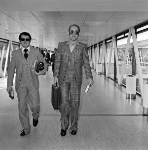 Images Dated 13th June 1976: Elton John, with his manager John Reid, leaving Heathrow Airport for Helsinki where he