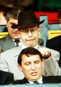 Elton John Singer & Chairman of Watford FC pulls a funny face at Manager Graham Taylor