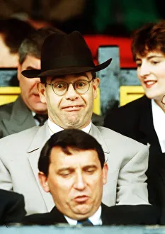 Elton John Singer & Chairman of Watford FC pulls a funny face at Manager Graham Taylor