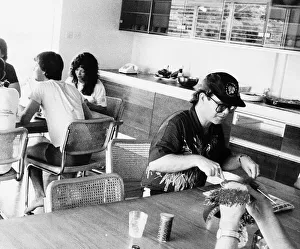 Elton john the singrer man sitting dinner table eating