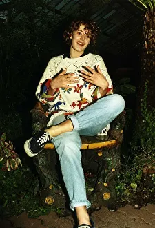 00131 Prints: Emily Lloyd Actress sitting cross legged in wood carved chair A©Mirrorpix