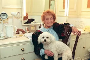 01529 Collection: Emily Perry sitting in her dressing room with her dog, West End production of Dame Edna