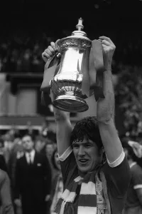 F A Cup Prints: Emlyn Hughes Liverpool captain holds up the FA Cup 1974 at Wembley after Liverpool
