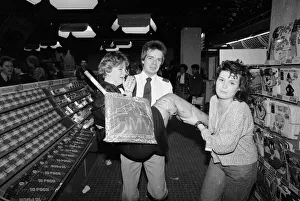 Security Guard Prints: An emotional fan of the pop group Bros is carried away from a record store by a security