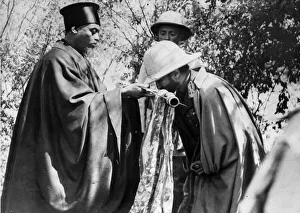 Emperor Haile Selassie kissing the cross offered by the High Priest of Debra Marcos after