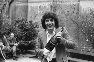 England footballer Kevin Keegan poses for photographers holding a large champagne bottle