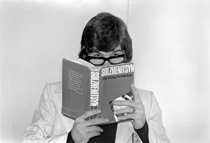 England footballer Malcolm MacDonald clowns around with glasses whilst reading