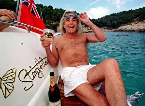Yachting Prints: English nightclub owner Peter Stringfellow enjoys a glass of Moet