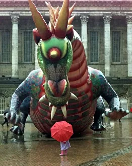 Brave Prints: Enter the dragon... a youngster braves the rain to take a look at a giant inflatable