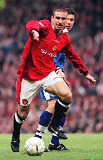 Eric Cantona fends off a Leicester defender during their match at Old Trafford