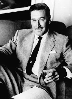 00148 Prints: Errol Flynn Actor- September 1977 sitting in a chair with a glass in his
