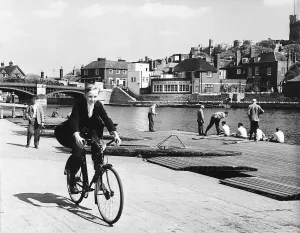 Bicycle Prints: Eton schoolboy cycling along the Thames in his school uniform Circa 1970