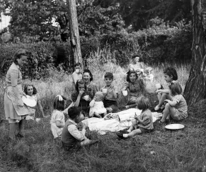 Evacuation Prints: Evacuees having a picnic under the cedar trees in the gardens of a church in Woburn Sands