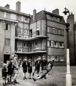 Evacuees returning from Leicestershire play in the street outside their tenement block in