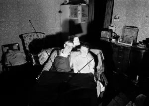 A evening in for a husband and wife watching a coin-operated television