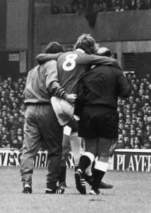 Painful Prints: Everton footballer Mike Bernard carried off the pitch aided by a trainer